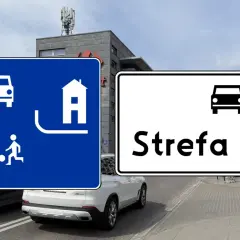 Znaki drogowe informują o wjeździe do strefy ruchu. Na niebieskim znaku widać pieszego, dziecko grające w piłkę i dom.