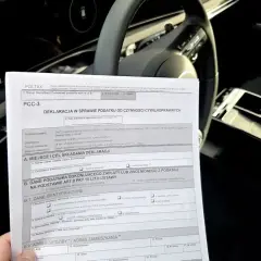 Formularz PCC-3 do rozliczenia podatku od zakupu samochodu. Wypełniony dokument leży na siedzeniu auta.