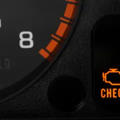 Pomarańczowa kontrolka "CHECK ENGINE" świeci się na desce rozdzielczej, sygnalizując potencjalny problem z silnikiem lub błąd DTC.