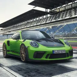 Zielony Porsche 911 GT3 RS na torze wyścigowym. Sprawdź porsche 911 gt3 rs cena i poczuj moc!