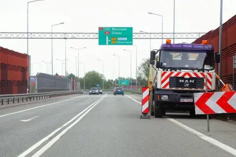 Ciężarówka MAN blokuje drogę, ostrzegając przed wyprzedzaniem na podwójnej ciągłej. Mandat za takie wykroczenie jest wysoki.
