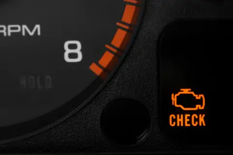Pomarańczowa kontrolka "CHECK ENGINE" świeci się na desce rozdzielczej, sygnalizując potencjalny problem z silnikiem lub błąd DTC.