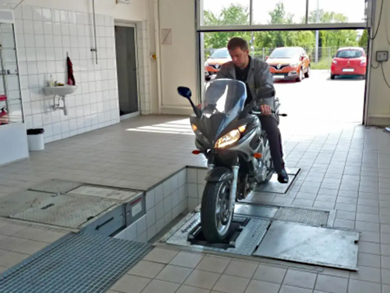 Mechanik na motocyklu na podnośniku. Zastanawiasz się, ile kosztuje przegląd motocykla?